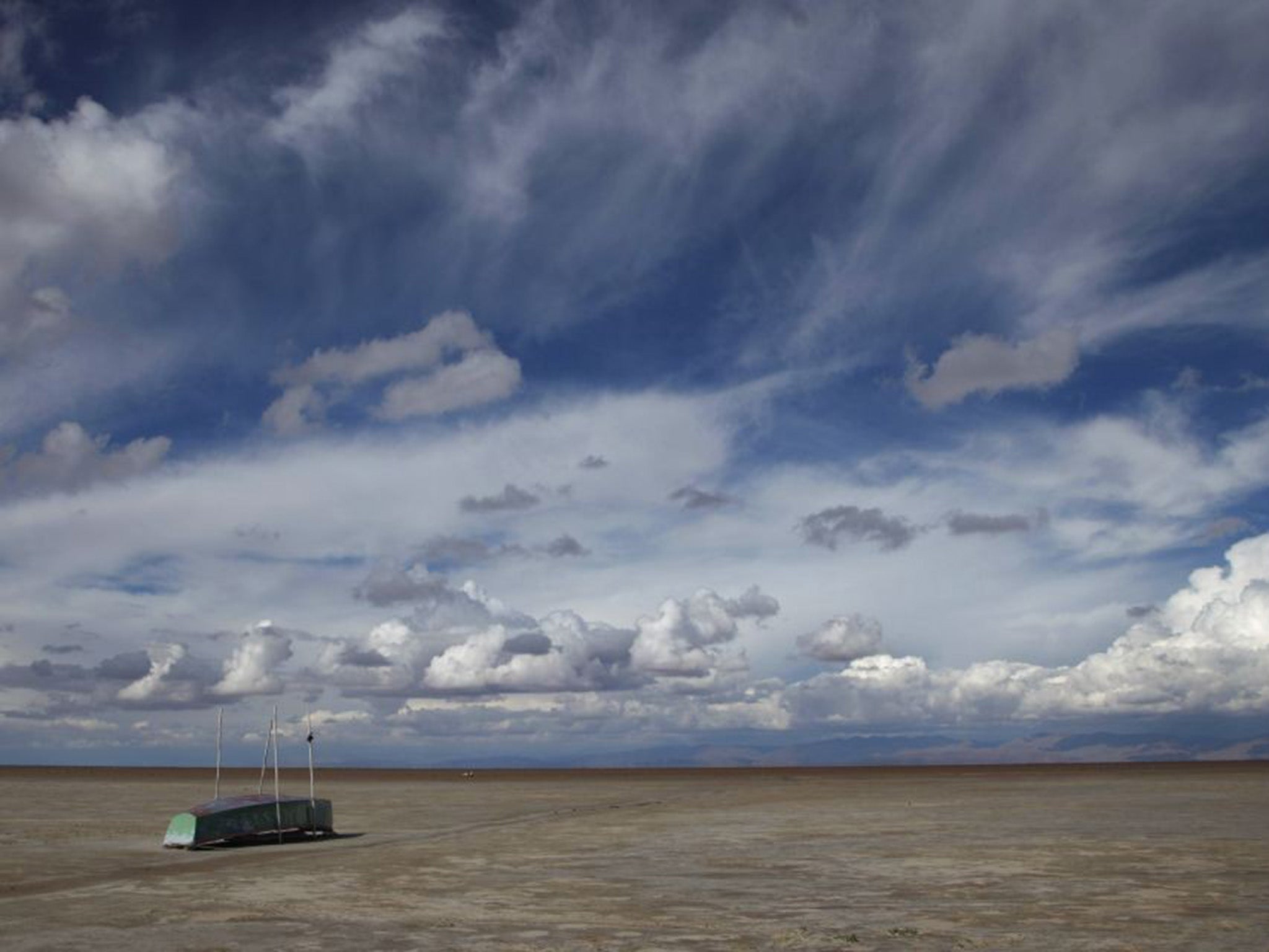 An abandoned fishing boat sits in the arid desert which was once Lake Poopo, Bolivia