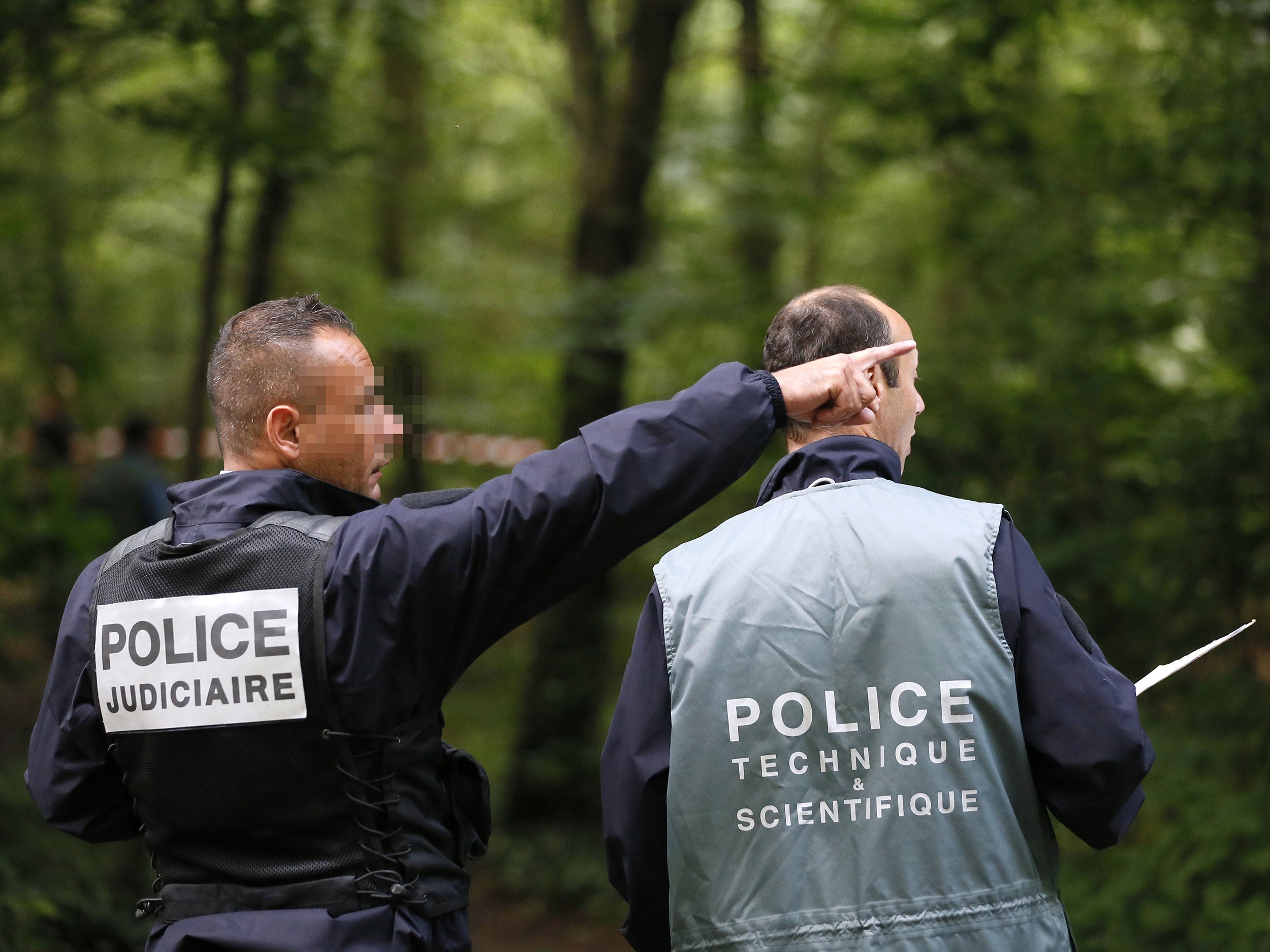 French policemen investigate Vincennes forest, where parts of the victims' bodies were found