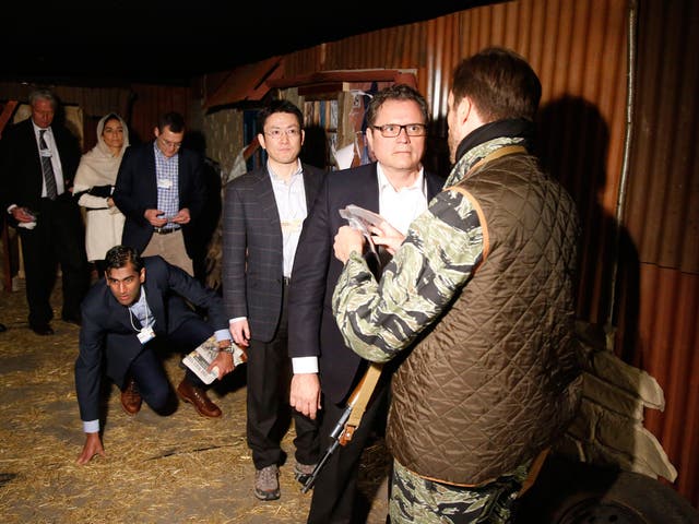 Davos delegates taking part in the 'A Day in the Life of a Refugee' simulated workshop have their ID papers checked by soldiers