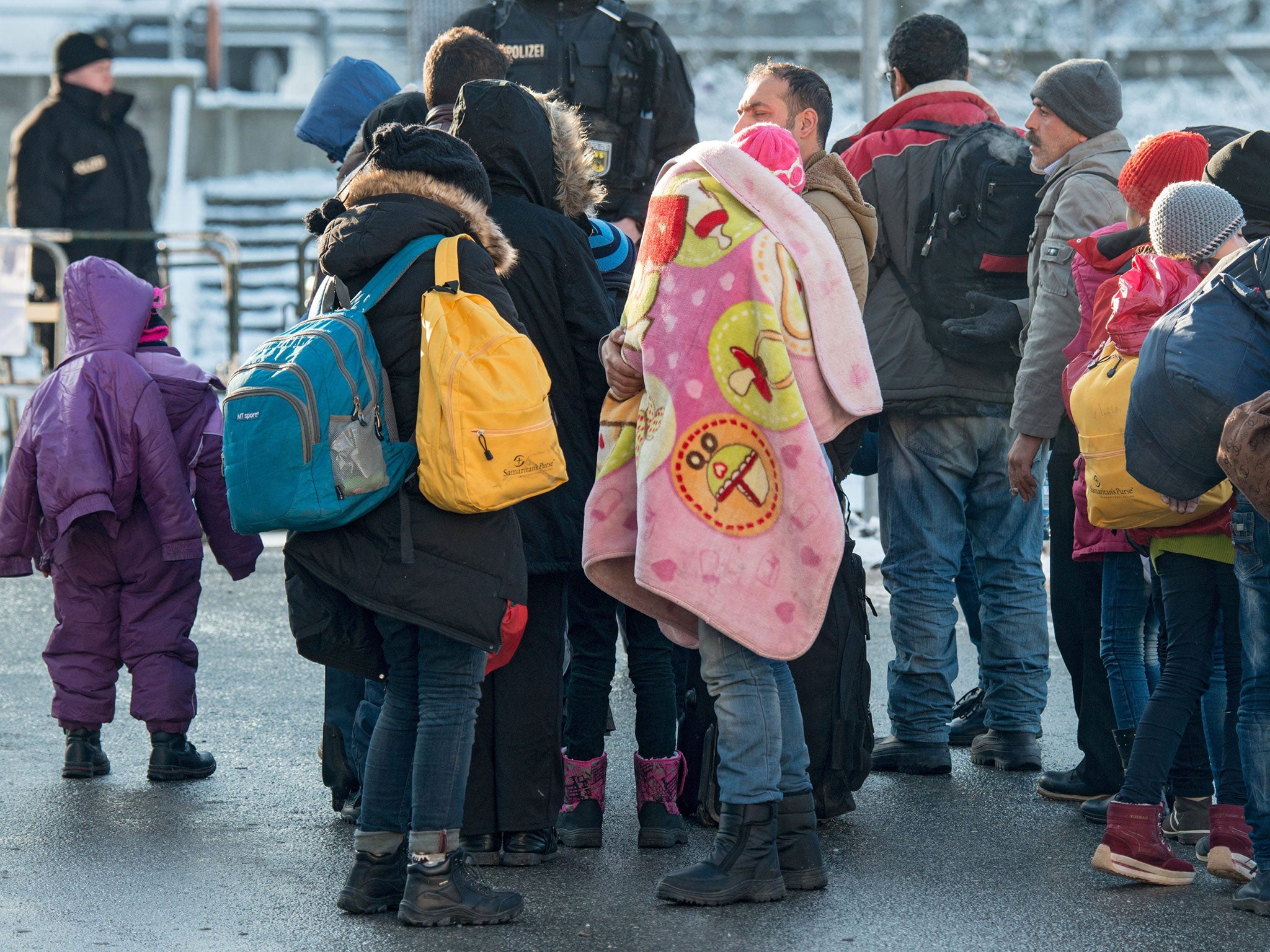 Refugees walk to a special train to Duesseldorf at the train station in Passau, Germany, 16 January 2016