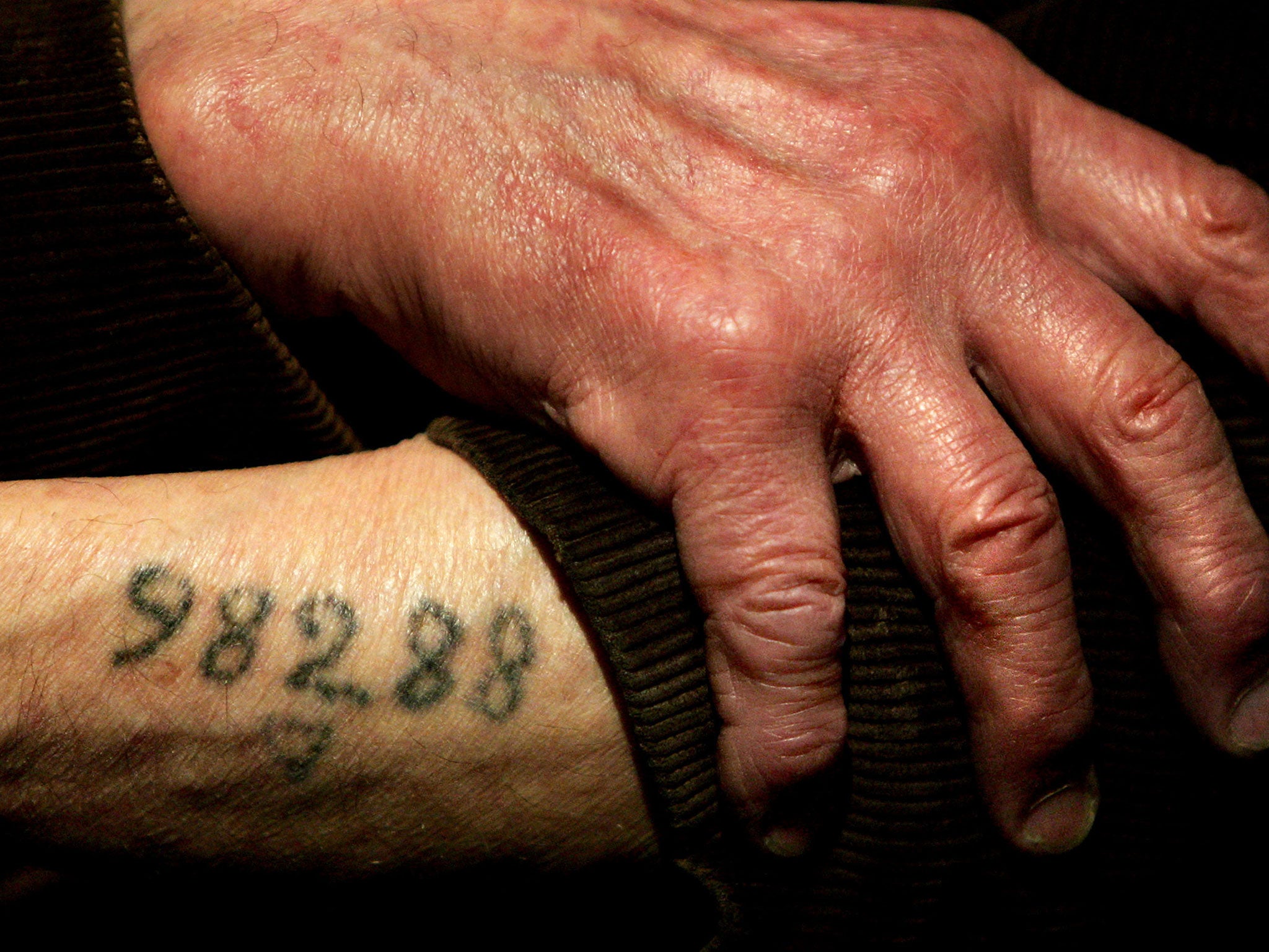 Auschwitz survivor Mr. Leon Greenman, prison number 98288, displays his number tattoo on 9 December, 2004, at the Jewish Museum in London