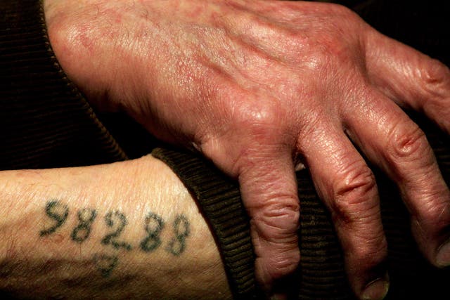Auschwitz survivor Mr. Leon Greenman, prison number 98288, displays his number tattoo on 9 December, 2004, at the Jewish Museum in London