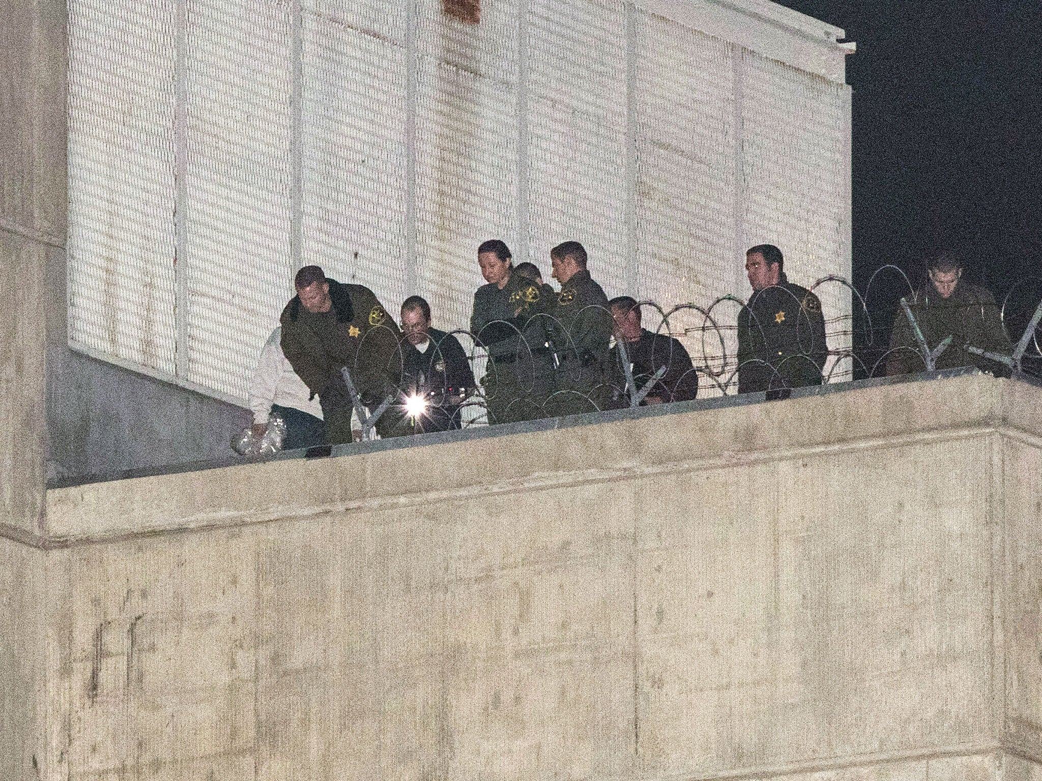 Orange County sheriff's deputies investigate early Saturday morning, 23 Jan, 2016, after three jail inmates charged with violent crimes escaped from Central Men's Jail in Santa Ana, California