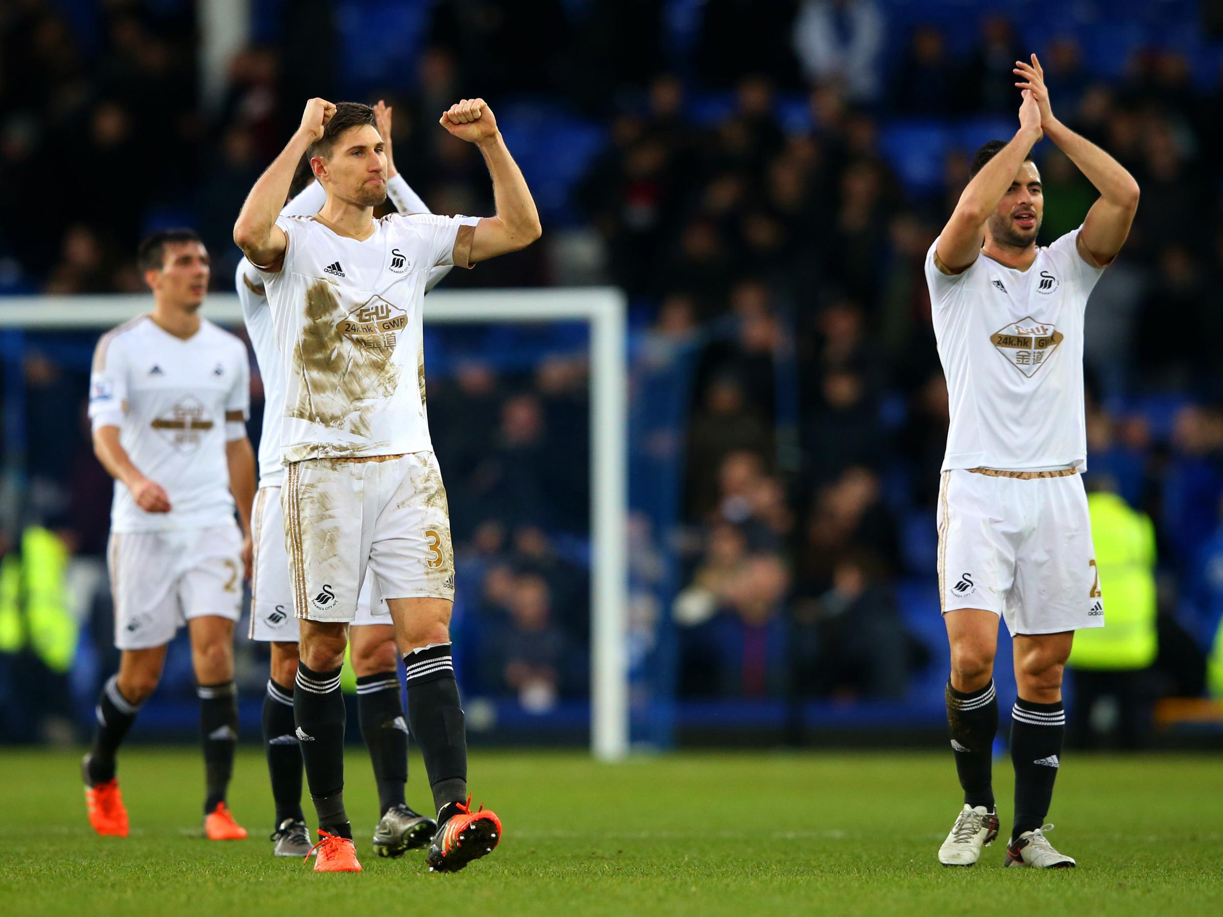 Swansea City players celebrate the 2-1 win at Everton