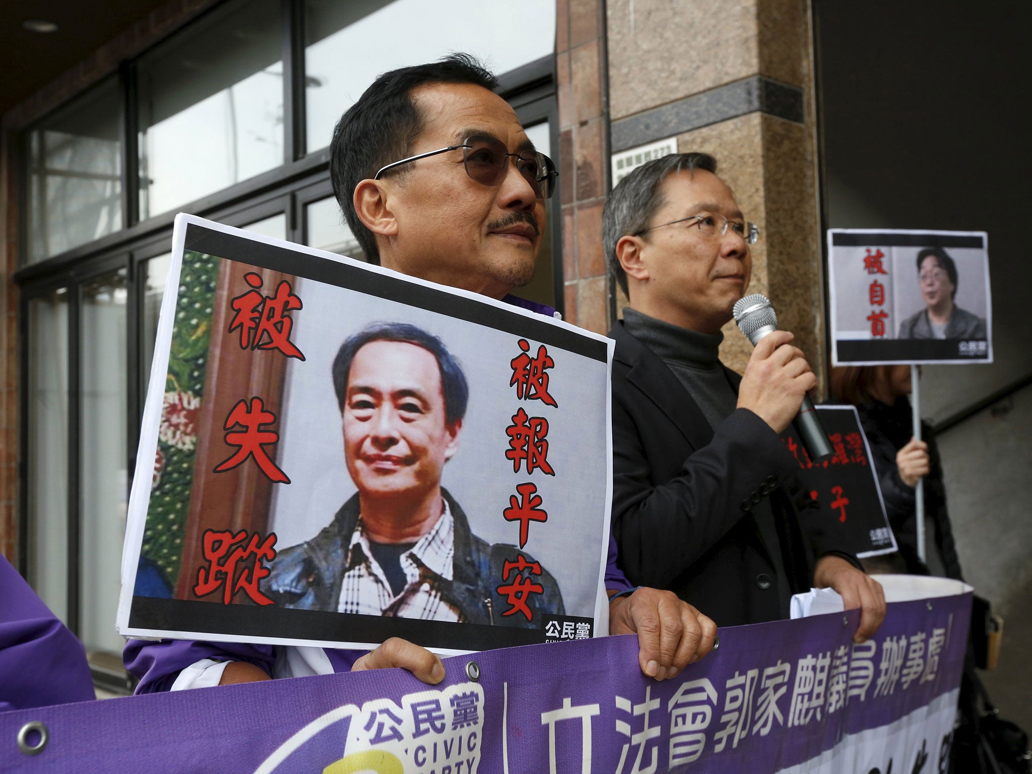 Protesters with portraits of Lee Bo, left, and Gui Minhai