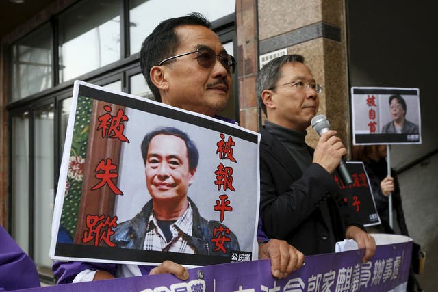 Protesters with portraits of Lee Bo, left, and Gui Minhai