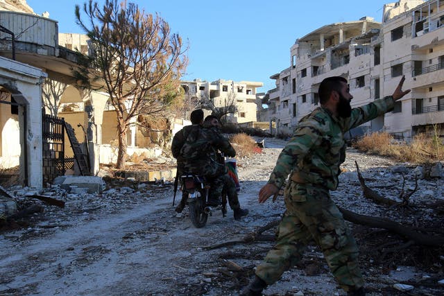A Syrian government soldier riding through the ruins of nearby Salma which was recaptured on 12 January