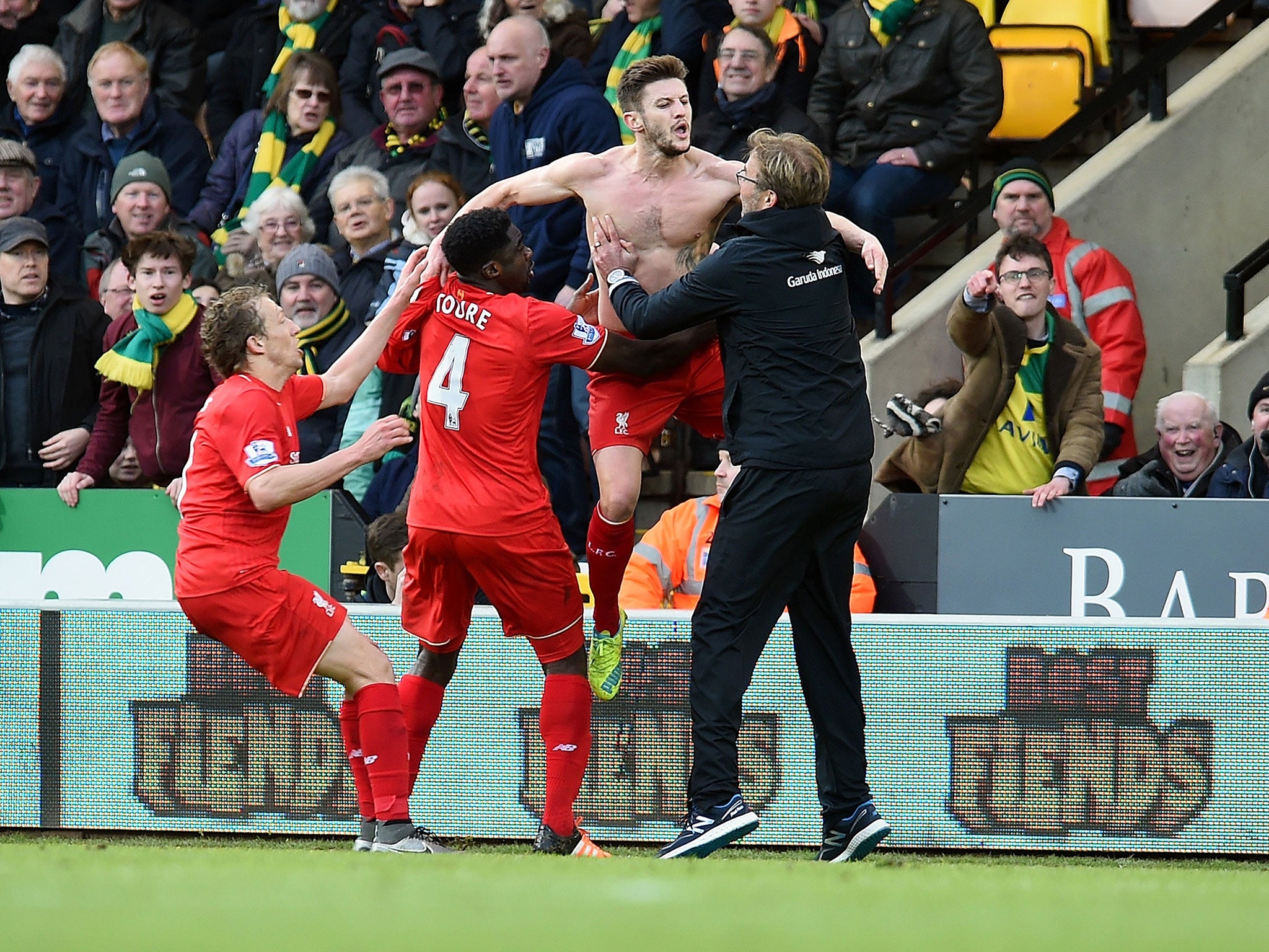 A shirtless Adam Lallana celebrates with manager Jürgen Klopp after scoring Liverpool’s late winner