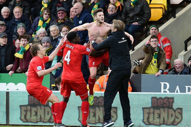 A shirtless Adam Lallana celebrates with manager Jürgen Klopp after scoring Liverpool’s late winner