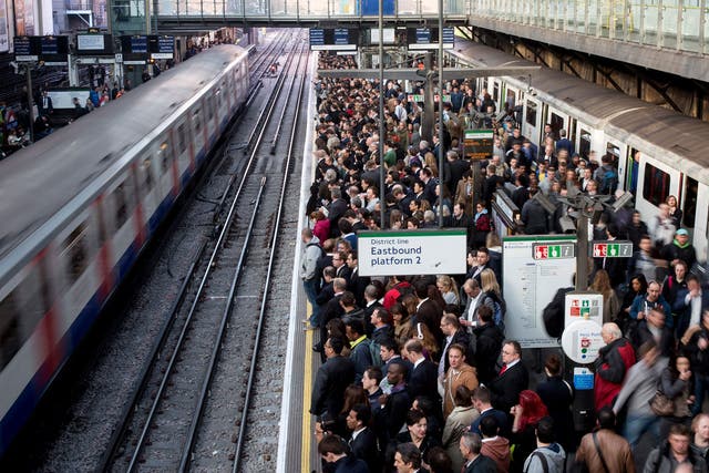 Commuters prepare to travel on the District Line of the London Underground during a 2014 strike