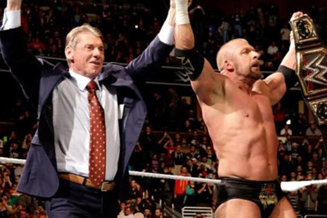 Triple H celebrates his win with Vince McMahon and Stephanie McMahon