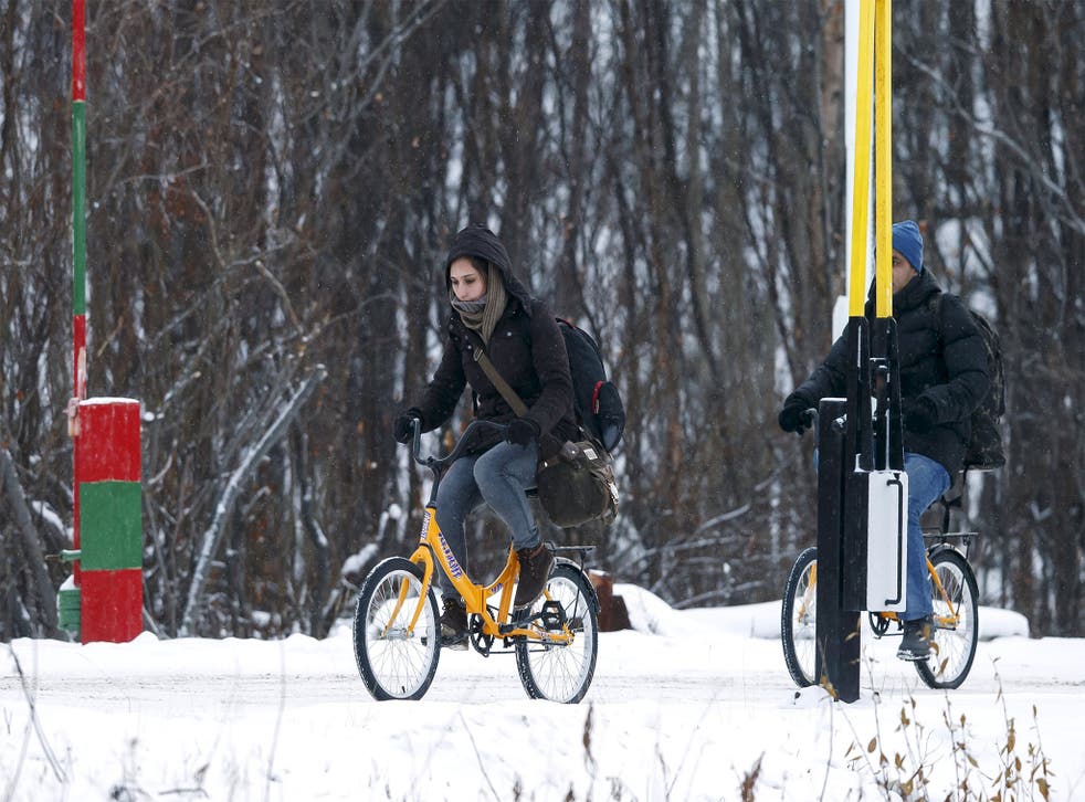 <p>Two refugees attempt to cross the Norwegian border in the nearby town of Storskog</p>