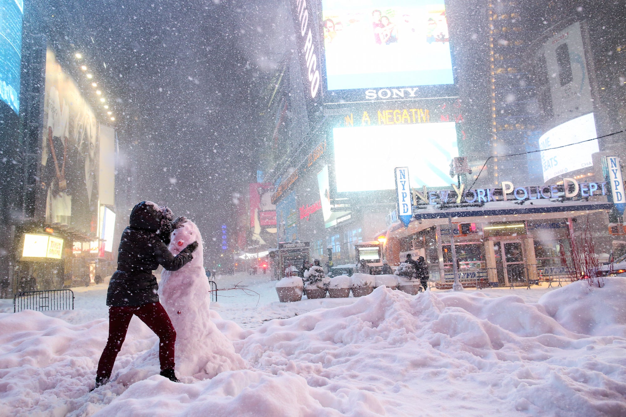 &#13;
A woman decorates a snowman in Times Square during the second largest blizzard in New York City's history. Yana Paskova/Getty&#13;