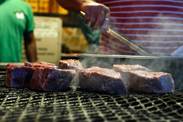 Red meat sizzles on a grill