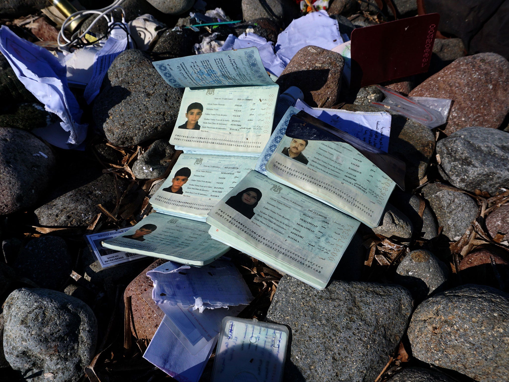 A picture taken on October 30, 2015 shows the passports of members of a family who drowned after the boat transporting them sank, on a beach on the Greek island of Lesbos.
