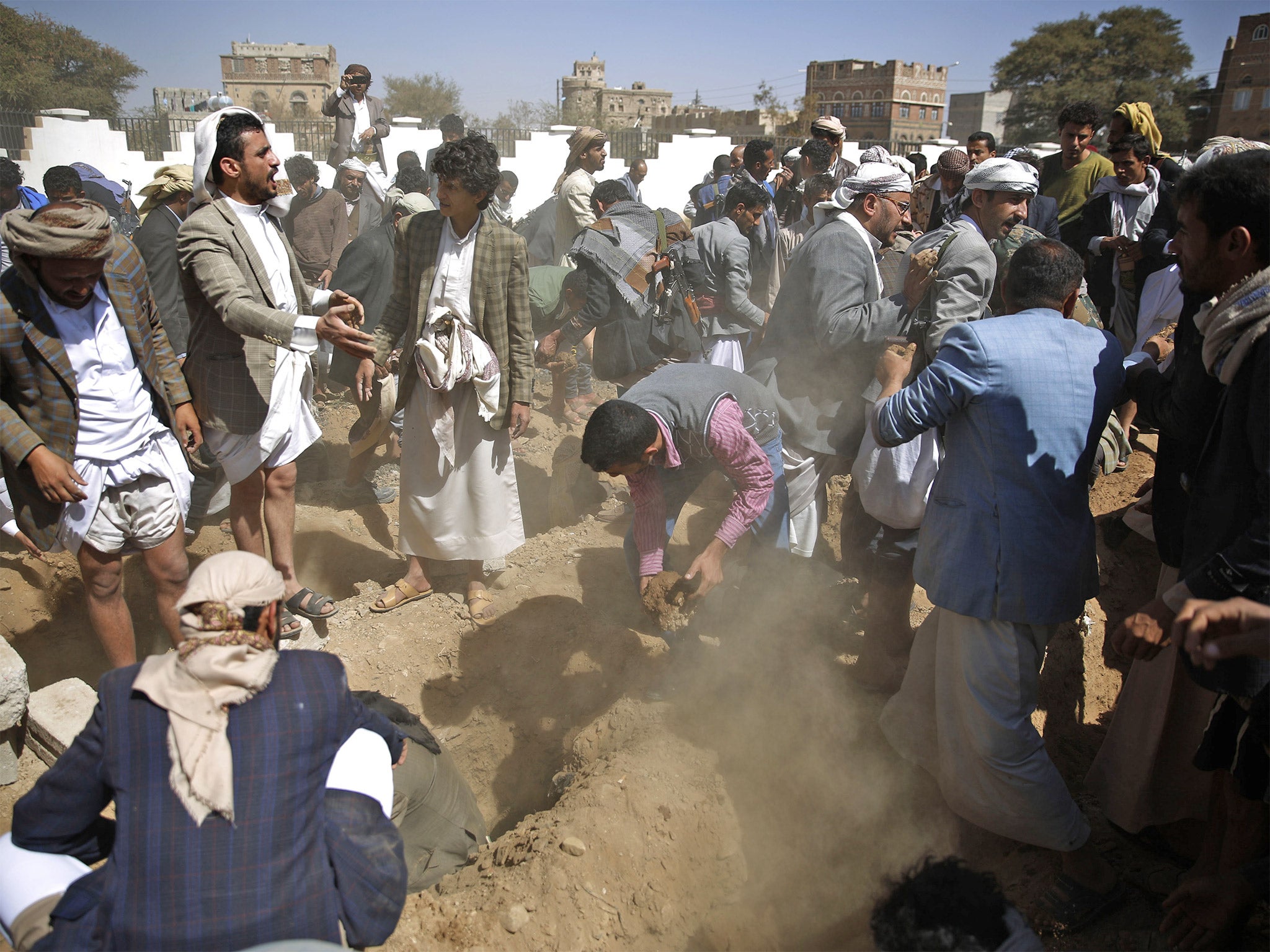 People bury the body of a judge who was killed along with his family by a Saudi-led airstrike, on Tuesday