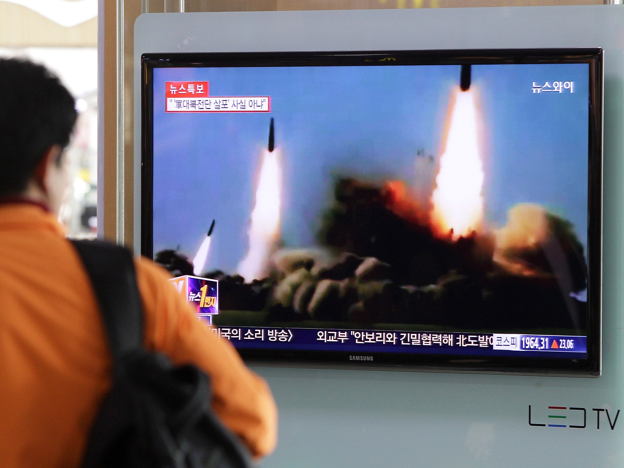 A man watches South Korean television reporting a North Korean missile launch in 2014