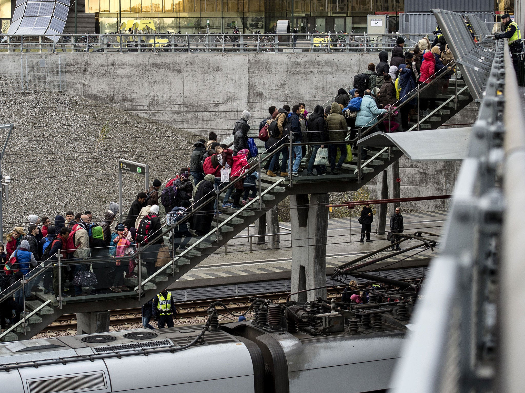 Police organise a line of refugees on the stairway leading up from the trains arriving from Denmark at the Hyllie train station outside Malmo, Sweden, in November 2015