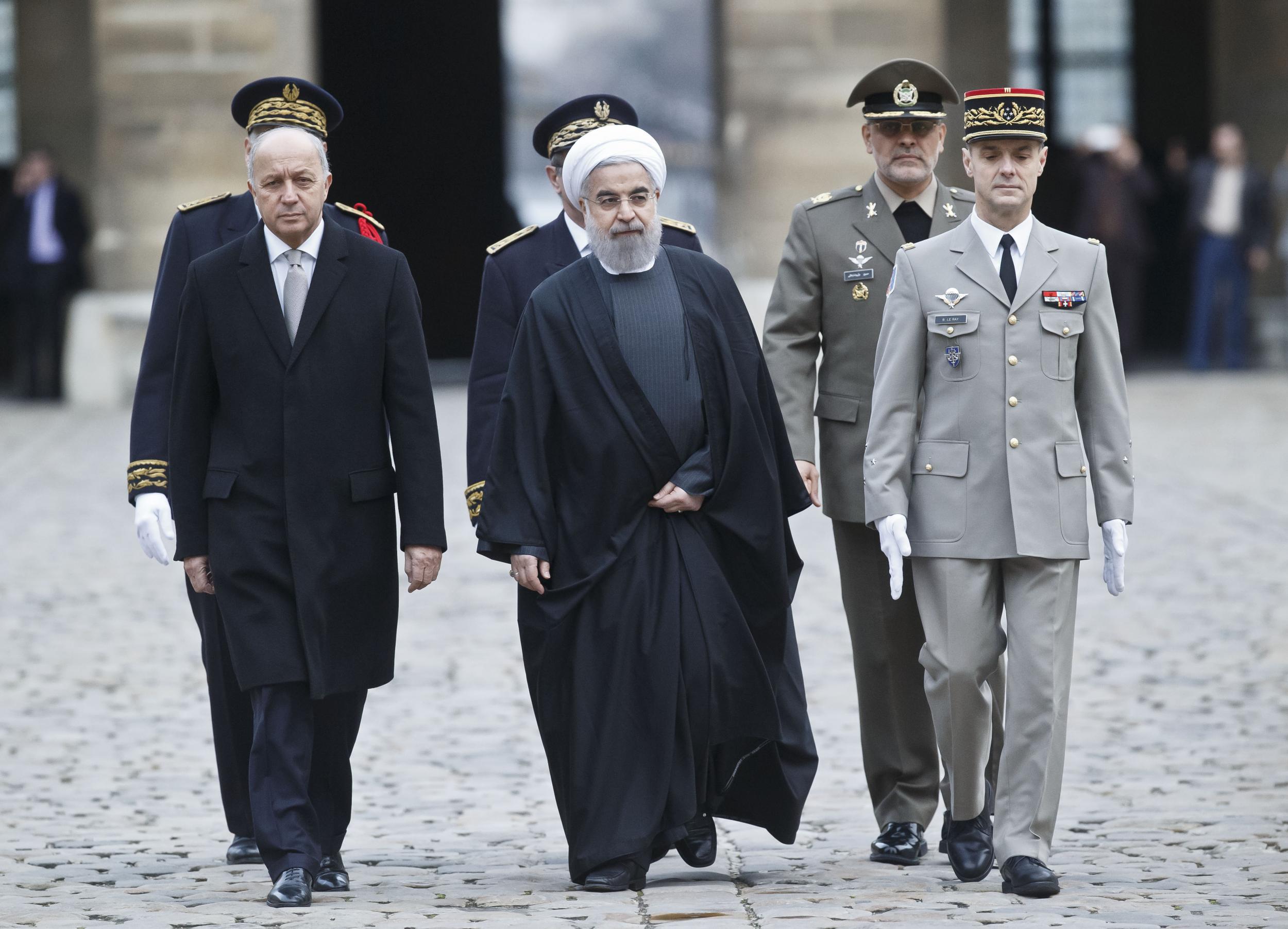 French Foreign Minister Laurent Fabius (left) greets Iranian President Hassan Rouhani during an official welcoming ceremony at the Invalides in Paris
