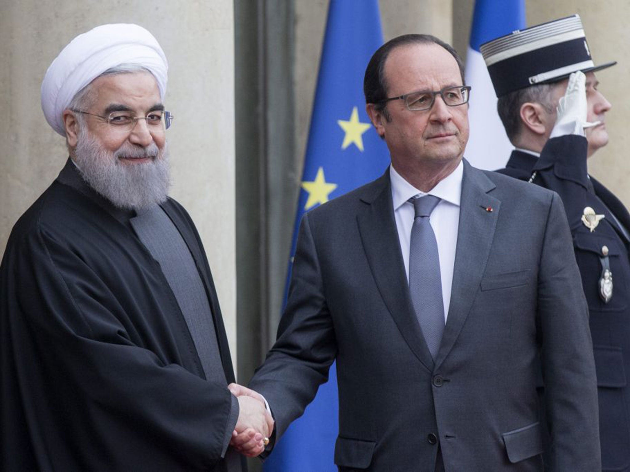 Iranian President Hassan Rouhani, left, is welcomed by French President Francois Hollande upon his arrival at the Elysee Palace on Monday