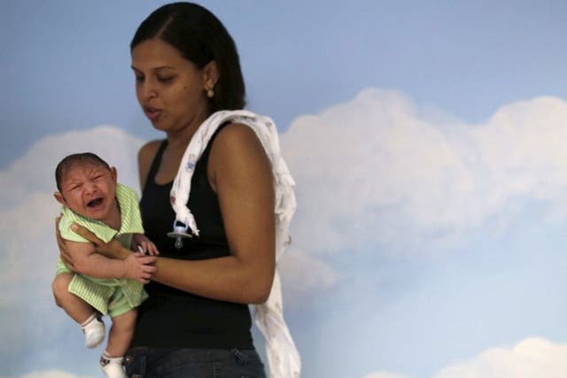 Daniele Ferreira holds her son Juan Pedro during a session to stimulate the development of his eyesight at the Altino Ventura rehabilitation center in Recife, Brazil