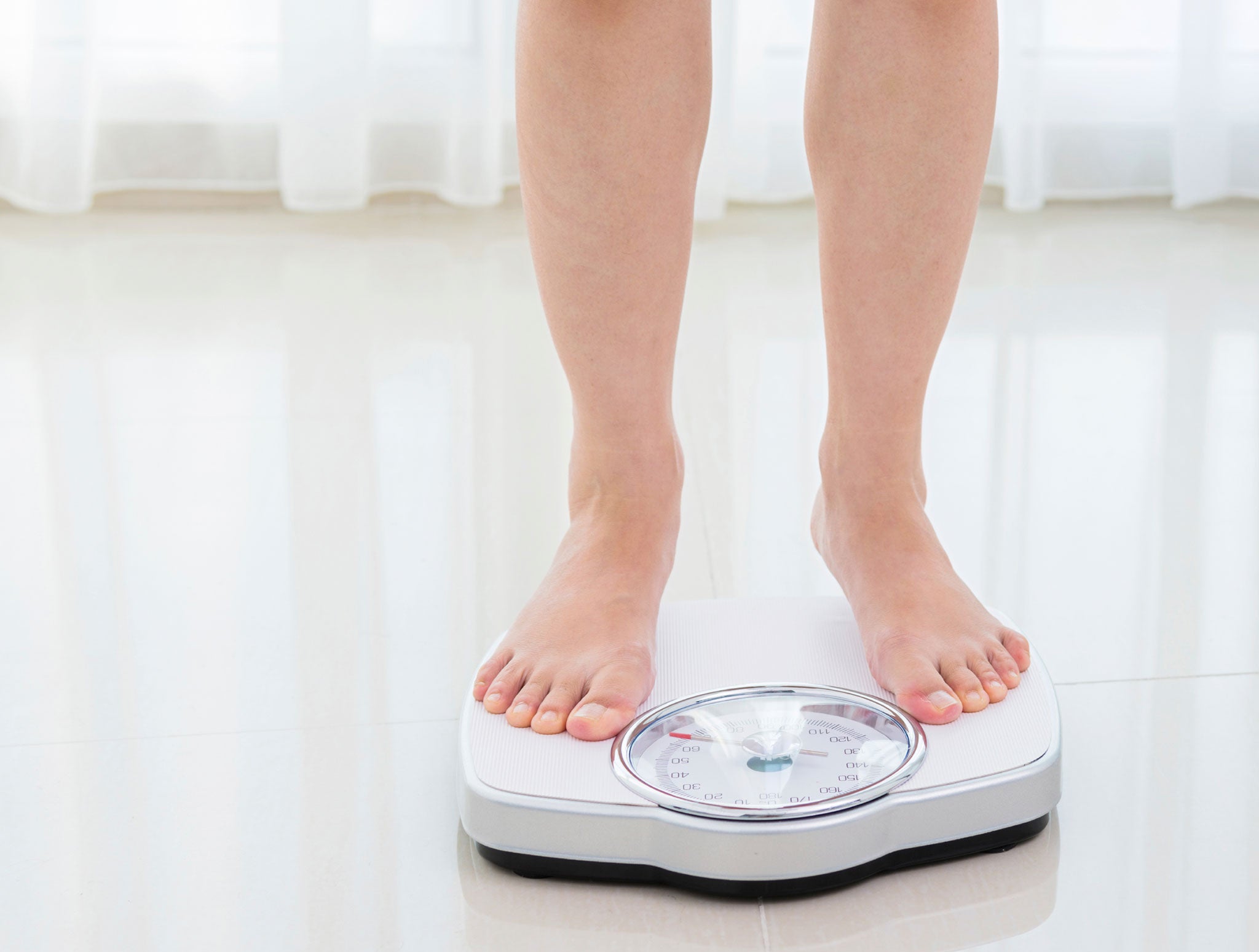 Top view of feet on weighing scale. Women weigh on a weight balance scale  after diet control. Healthy body weight. Weight and fat loss concept. Weight  measure machine. Body Mass Index or