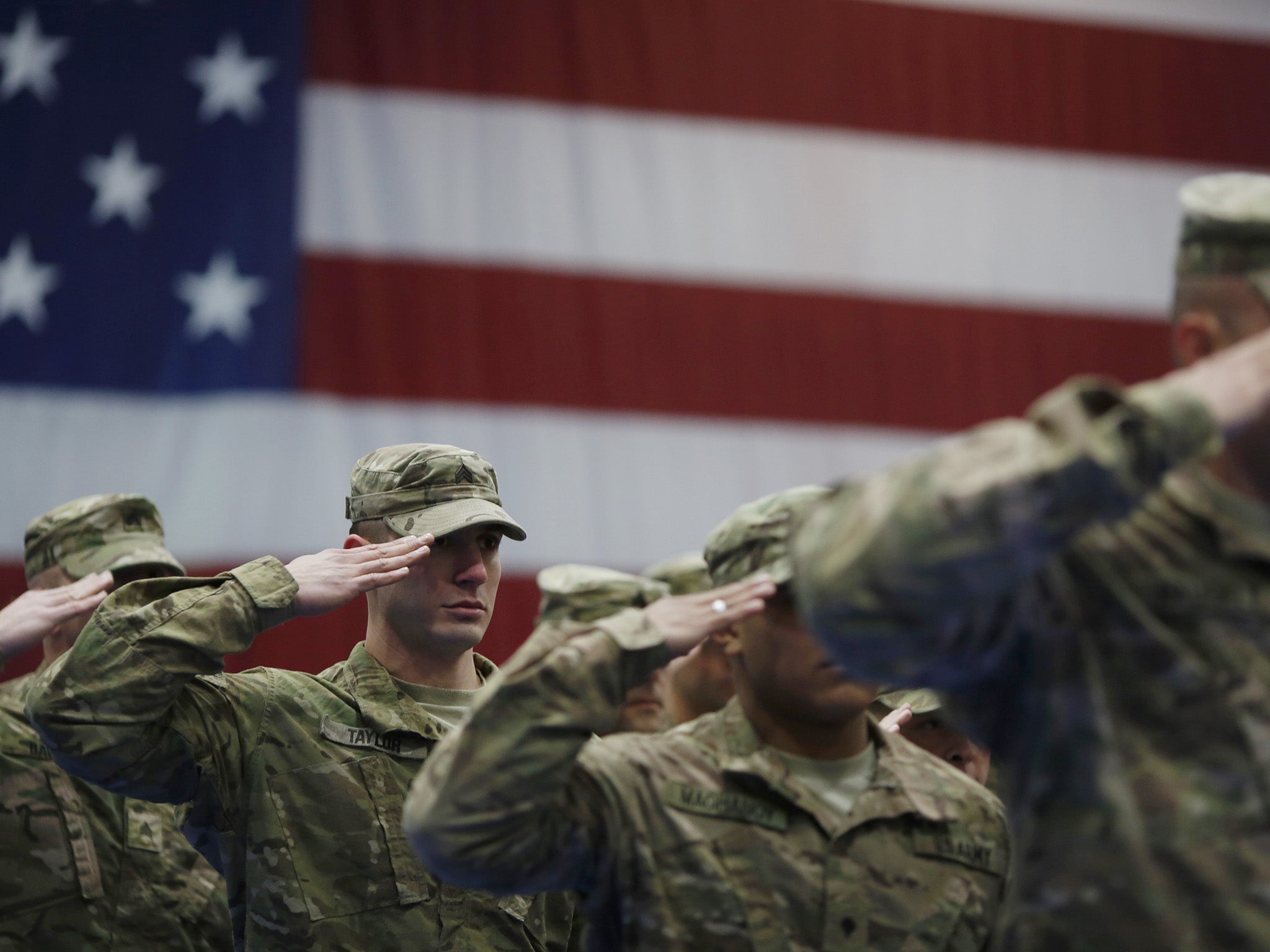 Soldiers salute during the playing of the Star Spangled Banner during a homecoming ceremony at Fort Knox, Kentucky