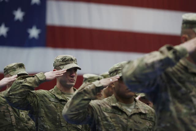 Soldiers salute during the playing of the Star Spangled Banner during a homecoming ceremony at Fort Knox, Kentucky
