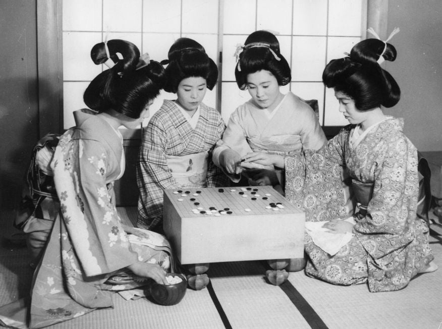 Japanese geishas playing the traditional Chinese game Go