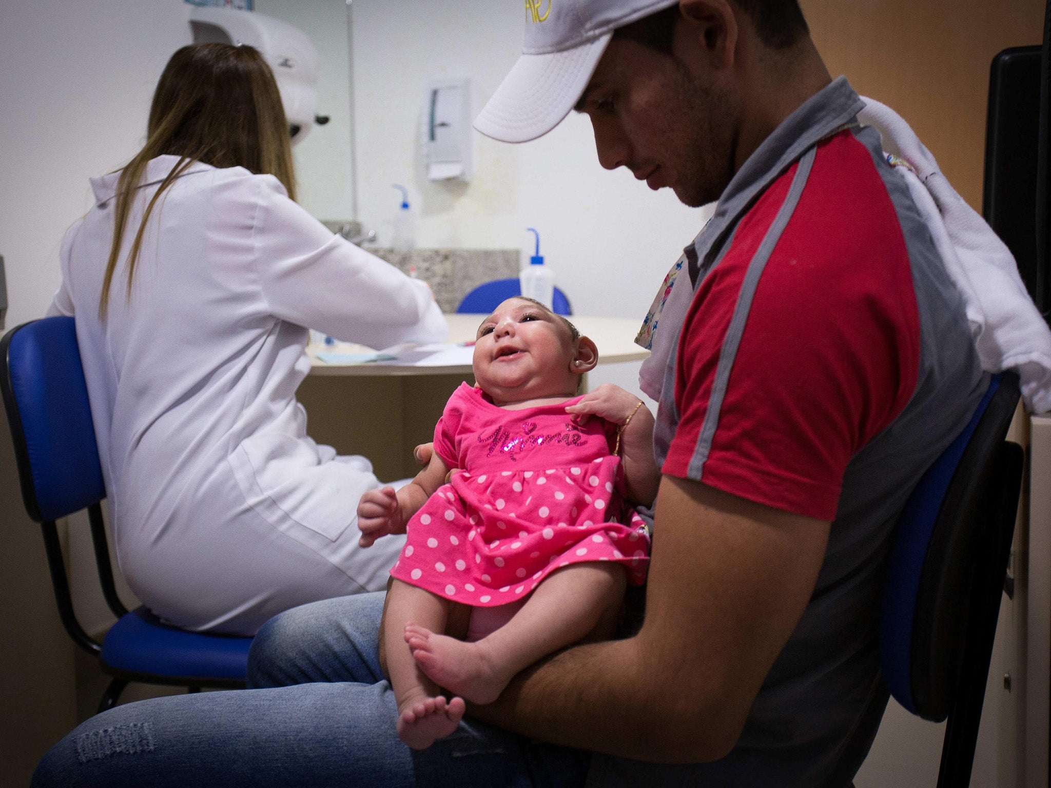 Ana Beatriz is held by her father Alipio Martin during a medical appointment at the Altino Ventura Foundation in Recife, Brazil