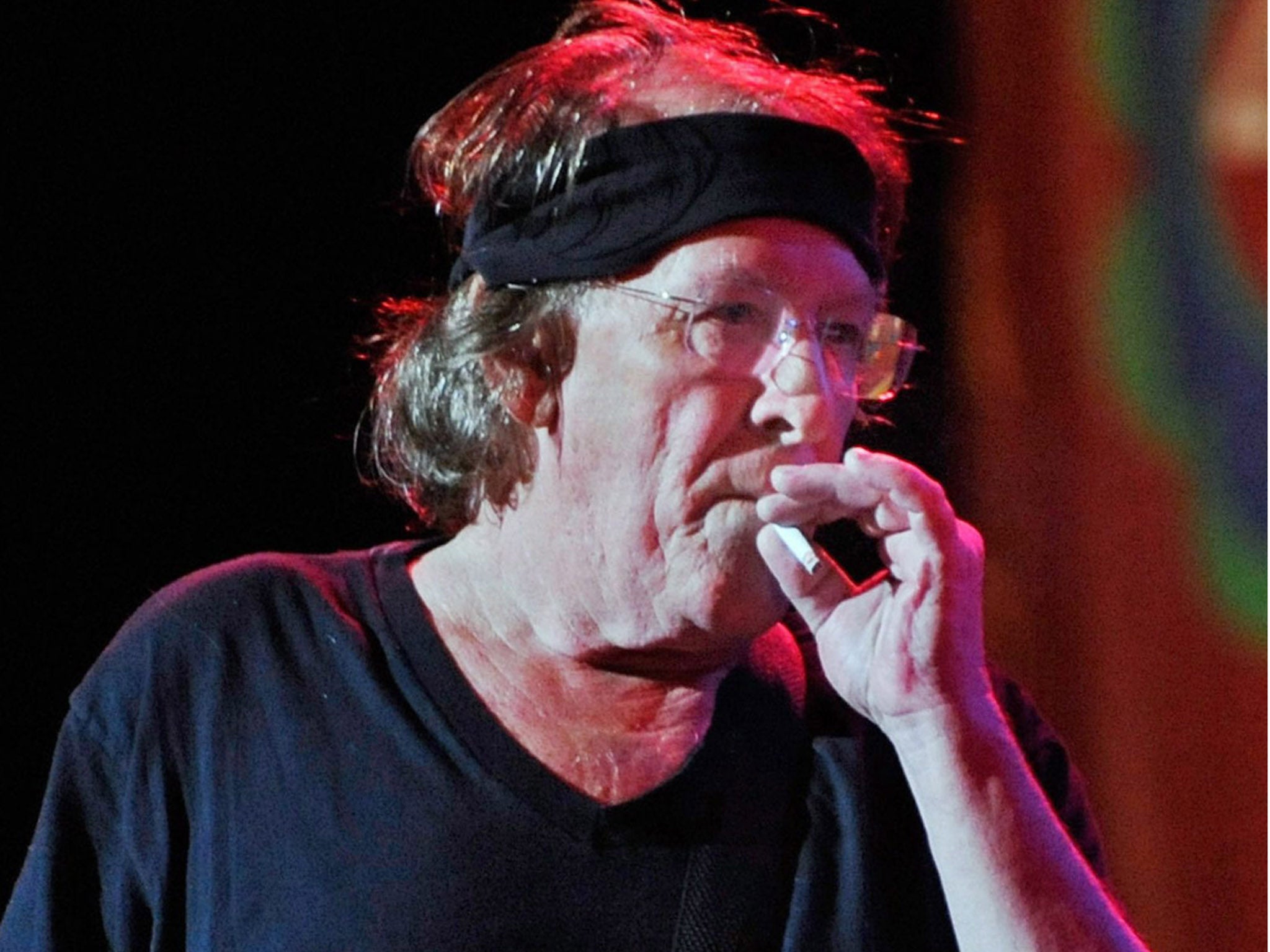 Paul Kantner performing on stage with the US rock band Jefferson Starship as he smokes a cigarette between songs, at the Bethel Woods Music Festival,