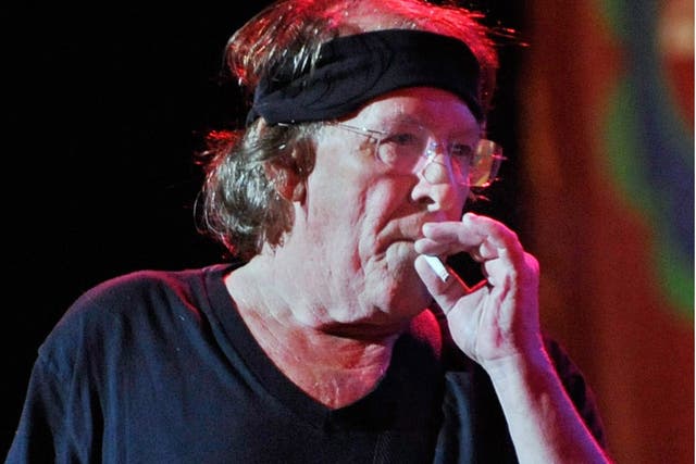 Paul Kantner performing on stage with the US rock band Jefferson Starship as he smokes a cigarette between songs, at the Bethel Woods Music Festival,