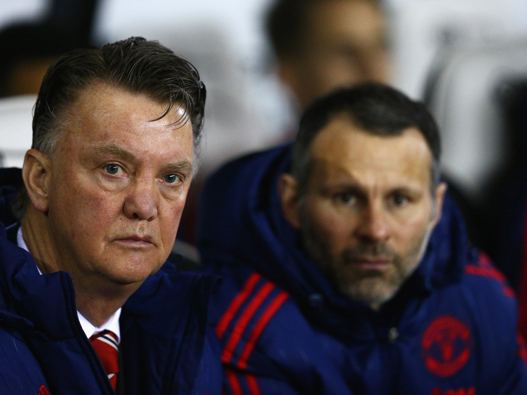 Louis van Gaal looks on from the dugout next to assistant manager Ryan Giggs