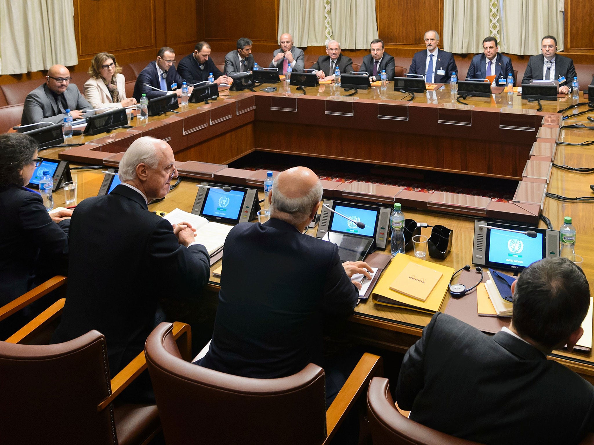 Staffan de Mistura (2nd L Below) faces Syrian ambassador to the UN and head of the government delegation Bashar al-Jaafari (4th R Above) at the opening of Syrian peace talks with the Syrian government delegation at the United Nations (UN) Offices in Geneva on January 29, 2016. FABRICE COFFRINI/AFP/Getty Images