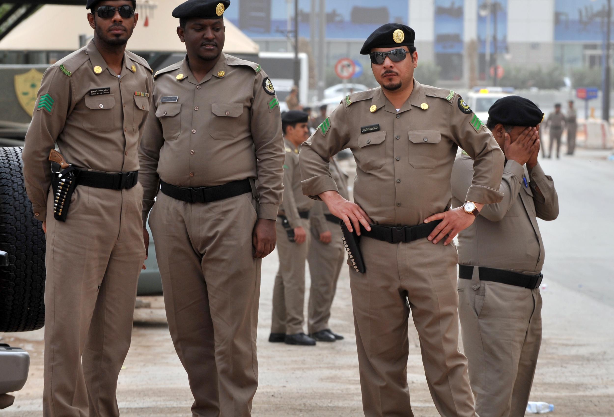 Saudi police stand guard in front of a government building ahead of a planned pro-democracy protest in 2011
