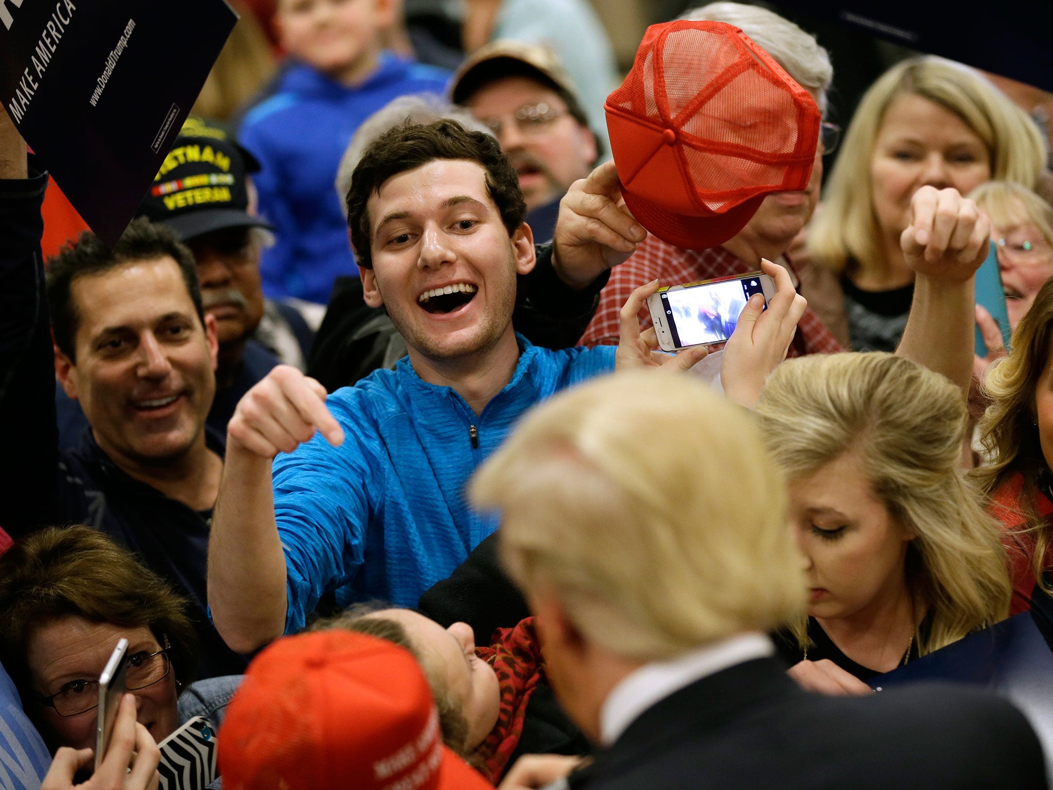 Supporters rush to meet Mr Trump at a rally in Clinton, Iowa