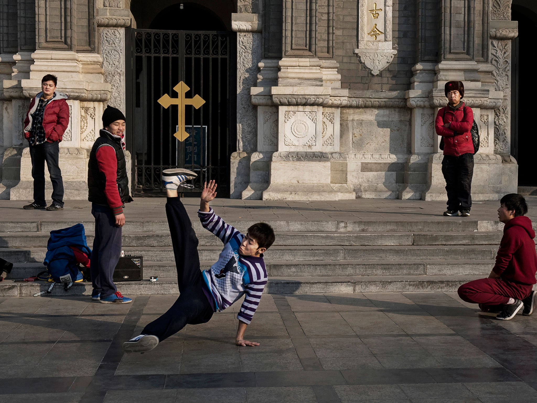 Chinese youths break dance in front of a church in a shopping district in central Beijing, China