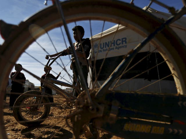 Syrian refugee children play with bicycles near their families' residence at Al Zaatari refugee camp in the Jordanian city of Mafraq, near the border with Syria