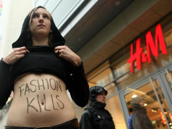 A young activist shows her stomach with the words 'Fashion Kills' during a demonstration