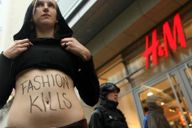 A young activist shows her stomach with the words 'Fashion Kills' during a demonstration