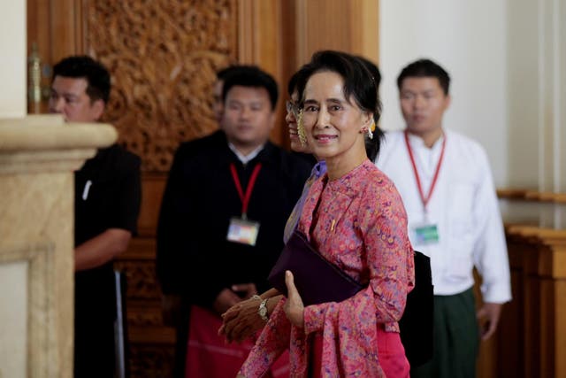 Aung San Suu Kyi (front) leaves after attending the first day of a new parliament session in Naypyitaw