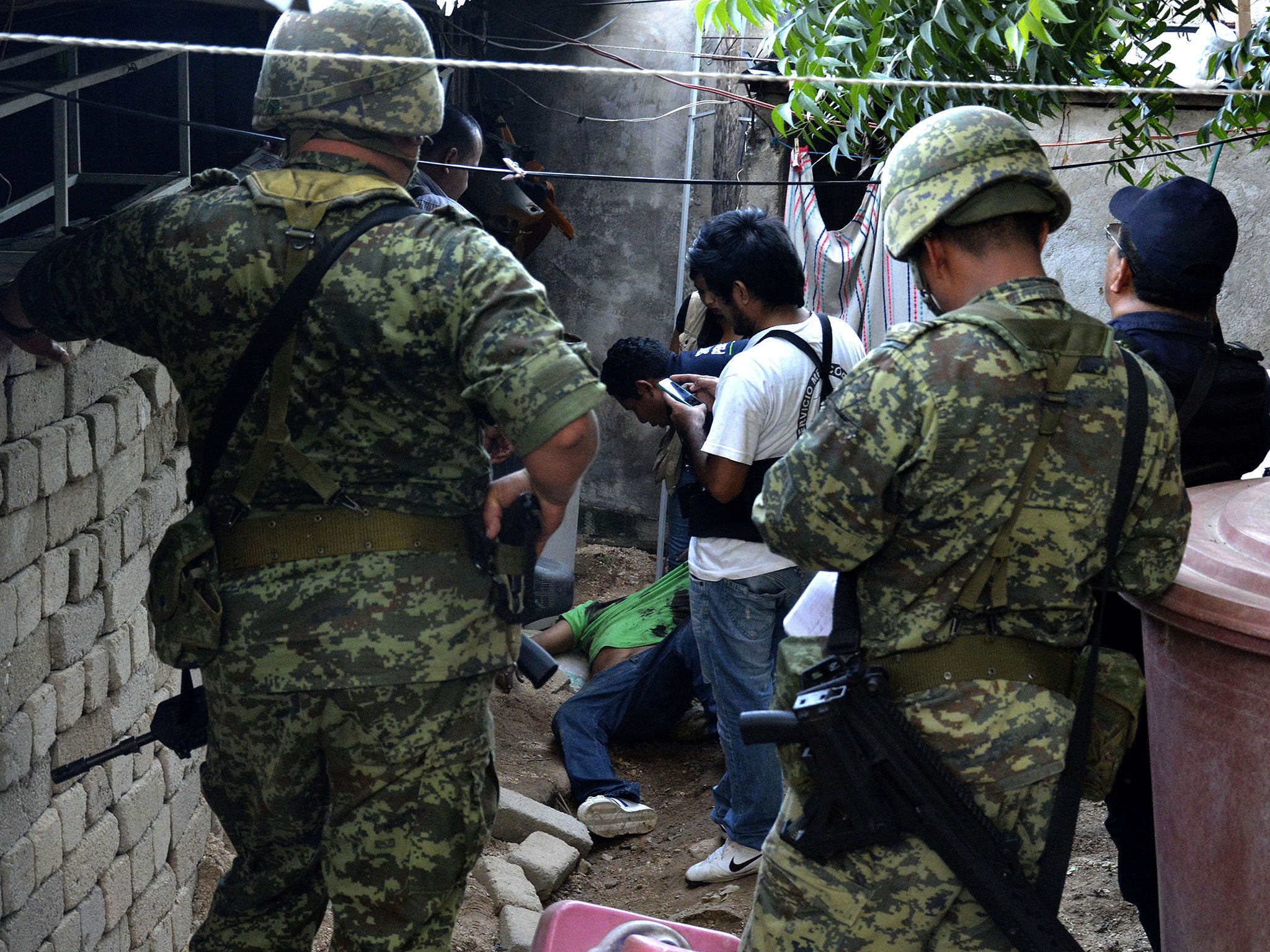 Mexican soldiers and forensic personnel work at a crime scene in Acapulco, Guerrero State, Mexico on 8 November, 2015