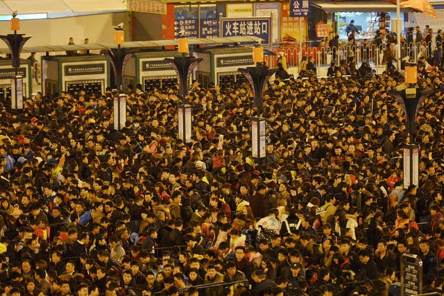 Passengers wait to enter a railway station after trains were delayed due to bad weather in southern China in Guangzhou