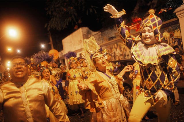 Revellers march during pre-Carnival celebrations in Olinda, Brazil, but many more events have been cancelled