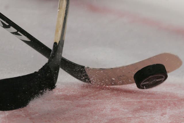 A general view of an ice hockey puck and sticks