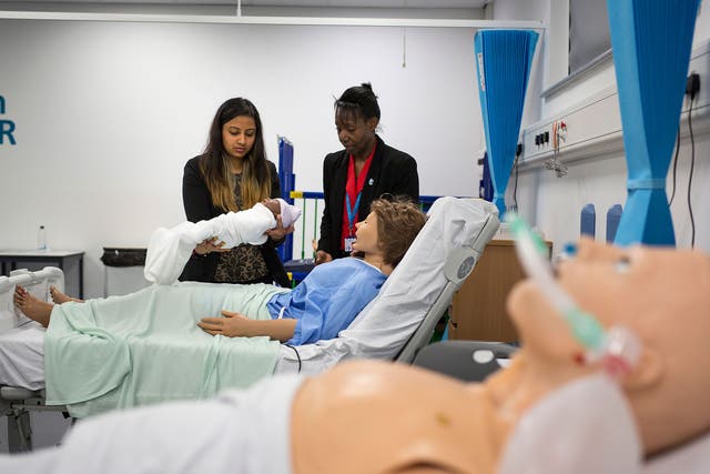 Students work at a mock-up ward at Health Futures, supervised by teacher Yvonne Howell