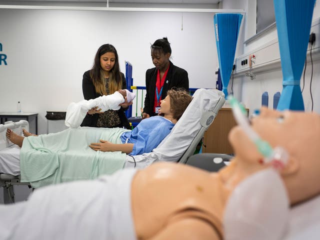 Students work at a mock-up ward at Health Futures, supervised by teacher Yvonne Howell