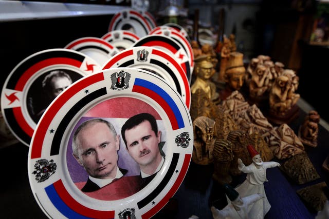 Porcelain plates bearing portraits of Syrian President Bashar al-Assad, right, and his Russian counterpart Vladimir Putin, left, are displayed at a handicrafts shop in the Syrian capital, Damascus
