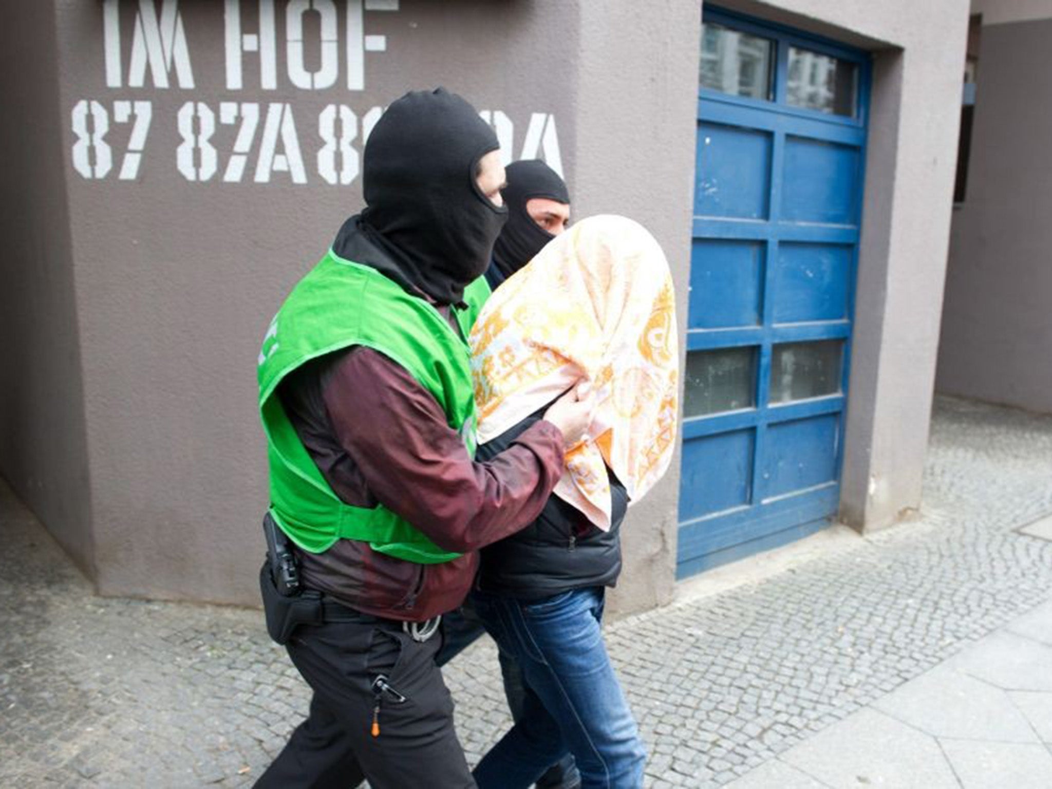 One of the terror suspects being led away by German police