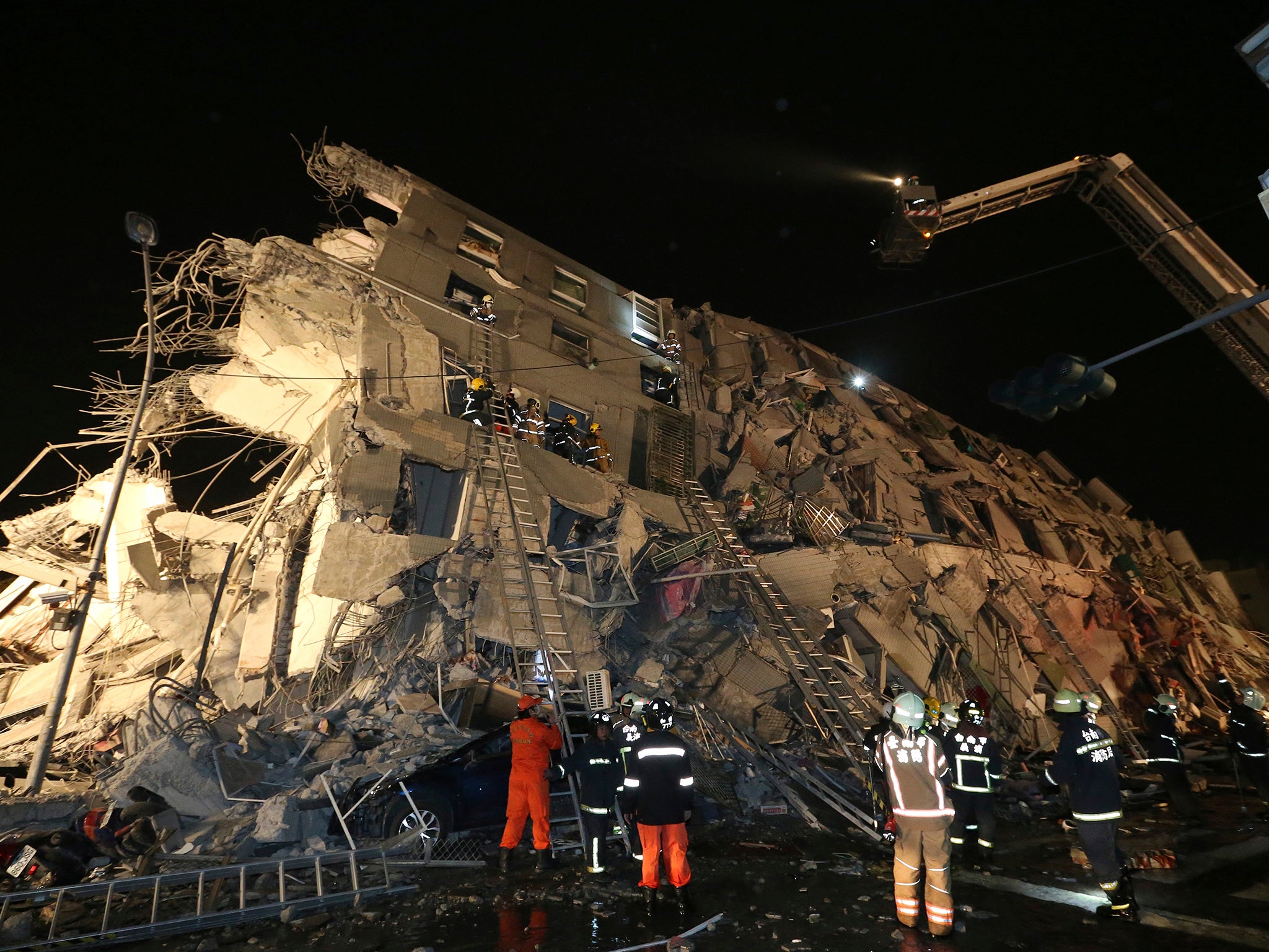 Rescue workers search a toppled building after an earthquake in Tainan, Taiwan